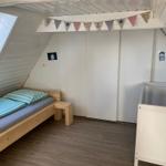 Kinderzimmer mit Bett, Kinderbett und Fenster unter Dachschrägen.