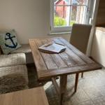 Holztisch mit Stuhl und Fensterblick auf Garten