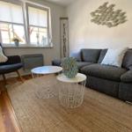 Wohnzimmer mit Sofa, zwei Tischen und Wanddekoration.