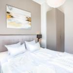 Schlafzimmer mit Bett, Kleiderschrank und Wandbild.
