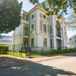 Historisches Gebäude mit weißen Wänden und goldenen Verzierungen an der Straße.