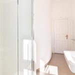 Badezimmer mit Dusche, Waschbecken und Heizkörper.