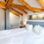 Schlafzimmer mit Doppelbett, Holzdecke und Kleiderschrank.