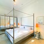 Schlafzimmer mit Doppelbett, Spiegelschrank und Nachttisch mit Lampe.