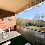Terrasse mit Tisch, Stühlen und Blick auf Garten und Häuser.