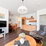 Wohn- und Essbereich mit Fernseher, Esstisch und bequemer Sitzgelegenheit.