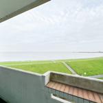 Terrasse mit Blick auf Grünflächen und Meer.