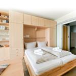 Schlafzimmer mit Doppelbett, integriertem Schrank und Bücherregal.