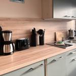 Küche mit Arbeitsplatte, Spüle, Kaffeemaschine und Toaster.