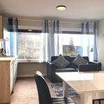 Wohnküche mit Essbereich, Sofa und Fenster mit blauen Vorhängen.