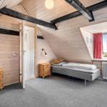 Bedroom with wooden walls, bed, nightstand, and window with view.