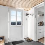 Entrance with door, shoes, and view into the kitchen.