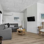 Living room with sofa, fireplace, TV, and chair.