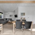 Living and dining area with sofa, dining table, and wood stove.