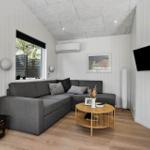 A living room with gray sofa, round table, and wall-mounted TV.