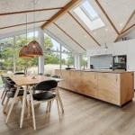 Kitchen and dining area with wooden surfaces and large windows for outdoor views.