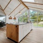 Kitchen with island, wood floor, and large window view of garden