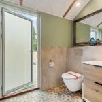 Bathroom with toilet, sink, and glass door to terrace.