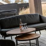 Deck with seating group, table, and wine bottle in background.