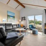 Living room with sofa, fireplace, and view of grassland.