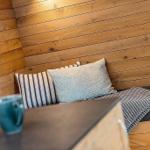 Corner bench with cushions and blanket against wood-paneled wall