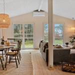 Essbereich mit Tisch und Stühlen, Wohnbereich mit Sofa und Fenstern zum Garten.