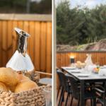 Außenbereich mit Tisch, Stühlen und Brotkorb. Hintergrund: Holzgeländer und Bäume.