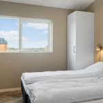 Schlafzimmer mit Bett, Kleiderschrank und Fenster mit Blick nach draußen.