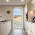 Moderne Küche mit Blick auf Garten und Nachbarhaus.