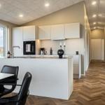 Moderne Küche mit Essbereich und Holzboden