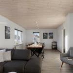 Living and dining area with sofa, chair, table, and windows.