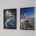 Two wall pictures show wind turbines and a lighthouse on the coast.