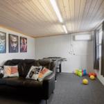 Room with sofa, foosball table, and toys. Wall art and air conditioner visible.