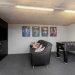 Room with sofa, foosball table, and wall art