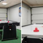 Air hockey table in garage with green floor and red pucks.