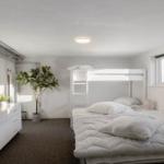 Bedroom with double bed, loft bed, and plants