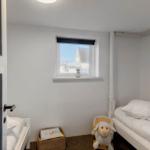 Room with two beds, window and rocking chair with sheep