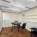 Terrace with table, chairs, and lounge chair. Wooden floor and window front.