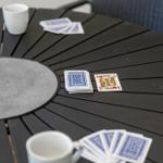 Round table with cards and mugs for outdoor games.