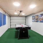 Room with air hockey table, ping pong and Minion pictures on the wall.