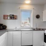 Kitchen with countertop, sink, stove, and window.