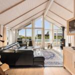 Living room with black leather sofa, wooden furniture, and balcony view.