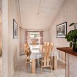 Dining room with wooden walls, table, chairs, and plant.