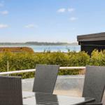 Terrace with seating and view of water and greenery.
