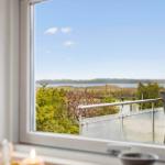 From the window, you can see a terrace with garden furniture and a lake.