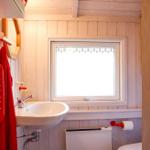 Bathroom with sink, window, and red towel rack.
