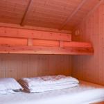 Room with two beds, wooden walls and ceiling, green lamp