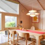 Dining room with wooden table, chairs, and large window to the garden.