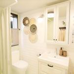 Bathroom with shower, sink, and mirror cabinet. Wall decor and towels hang on walls.