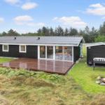 Ein Haus mit Terrasse, Grillplatz und Garten. Im Inneren ist eine Küche und Essbereich sichtbar.